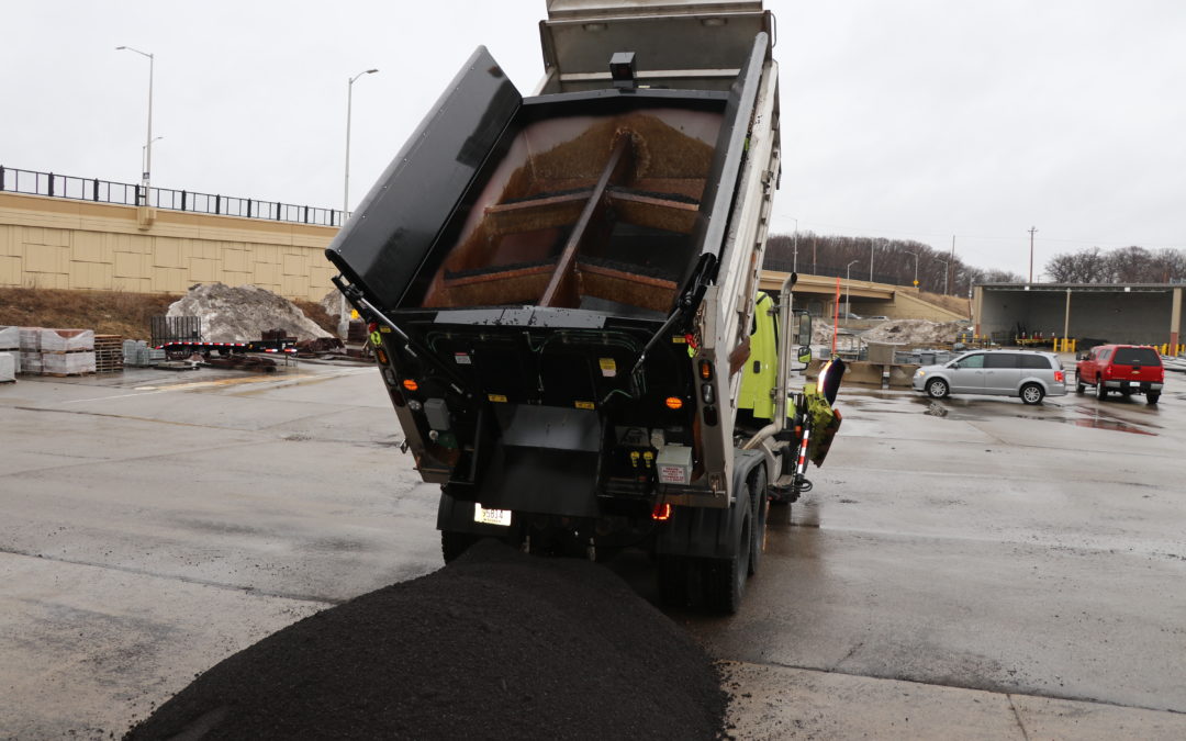A slip-in hot box dumps asphalt for repairing potholes.